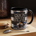 A black and white mug with a graphic design featuring a police officer and the text "Back & Body Hurts" on it, placed on a wooden surface next to a spoon.